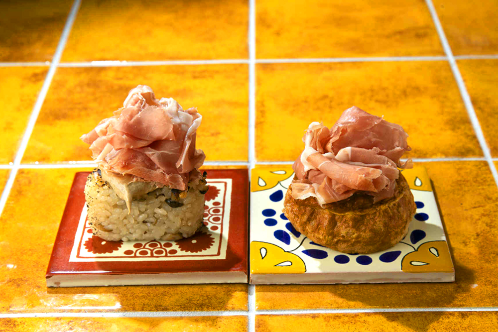 炊き込みご飯の旨みに、トリュフの香りとハモンのコクを加えた贅沢な味わいの‟炊き込みご飯おにぎり ハモン&トリュフソース添え(画像左)”と、卵のやさしい味わいにハモンの旨みを重ねた‟卵焼き ハモン添え(画像右)“。どちらもCAVAとの相性が抜群であり、和とスパニッシュのペアリングの極意を味わえる逸品だといっていい