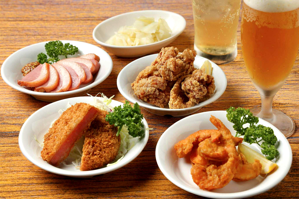 今回の出店にあたり、空港側からのリクエストとして‟夜時間の活性化“が挙がった。そこで、お酒との相性を意識した小皿メニューも充実させた。「紅茶鴨のスモーク(画像左奥)」など珍しいメニューもあり、帰着後のひと息はもちろん、見送りの一献にも気軽に立ち寄れるのが嬉しい