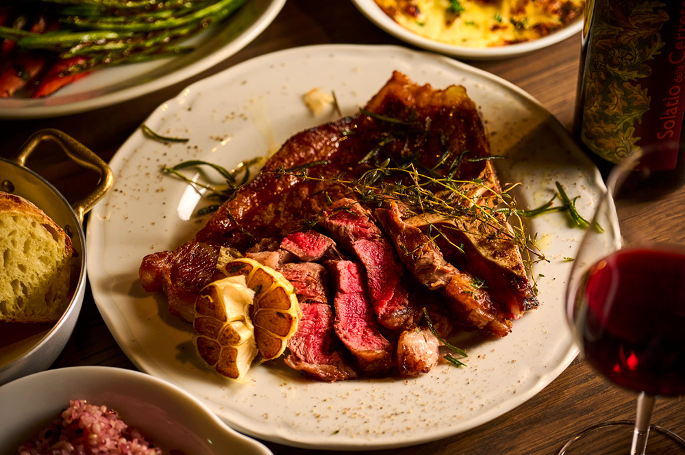 ディナータイムにはイタリアンを軸に、肉や魚のグリル、前菜、パスタ、リゾットまで幅広いメニューを展開する。日光サーモンや那須ヤシオポーク、足利マール牛に栃木野菜をふんだんに使った料理が多く並び、グループでの訪問ではシェアしながら楽しめるコースも用意されている(画像は‟LAZULI PLACE GRILL COURSE“から Tボーンステーキコース)