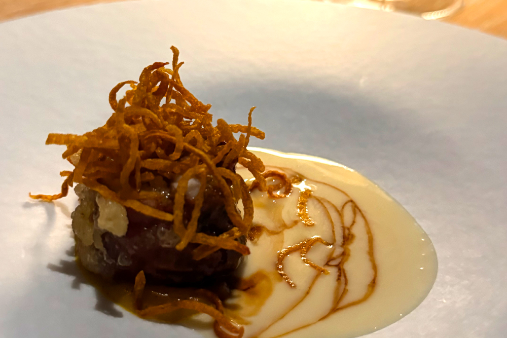 滋賀県出身の北村啓太シェフが率いる「apothéose」では、天然琵琶湖大鰻、みなくちファームのバターナッツ、萩の露‟雨垂れ石を穿つ“貴醸酒を用いた‟琵琶湖大鰻と穴子の生ハム包みフリット みなくちファームのバターナッツピュレ 萩の露 貴醸酒ソース“を提供。フランス時代から大切にしてきた食材や技法に滋賀県産食材を重ね、そのエスプリを受け継いだ一皿に仕上げという