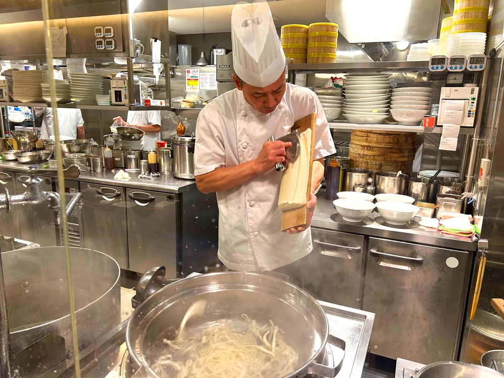 オープンキッチンでは、麺点師が刀削麺を削る光景も見ることができる。ちなみに同店の刀削麺は職人が粉から手作りし寝かせた生地から作られており、もちもちとした食感を楽しめるのが特徴だ