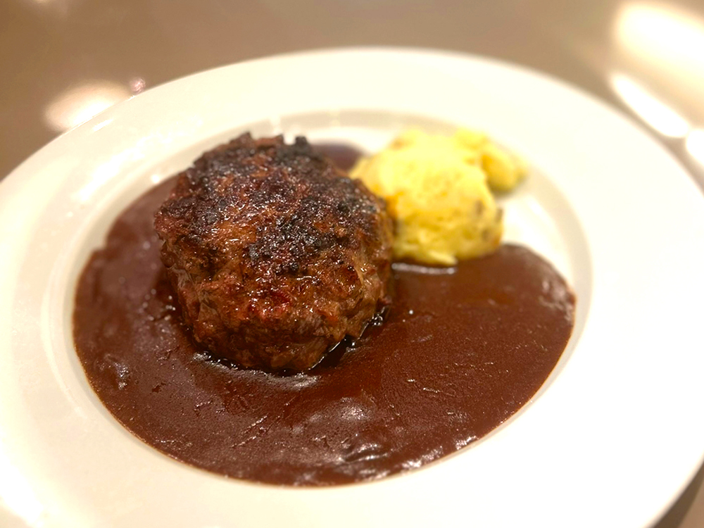 ランチで一番人気の‟黒毛和牛100%ハンバーグステーキ”。大挽、中挽、細挽、牛バラを手ごねし、ステークアッシュのイメージで作られた贅沢なハンバーグだ。昼はデミグラスソースで、夜は塩コショウとレモンを添えて提供されている