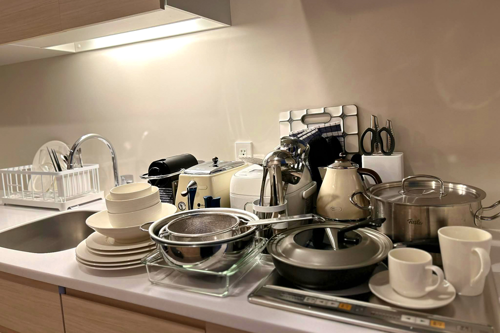 客室に設えられたキッチンウェア(※一部)。トースターや炊飯器、鍋類に加え、家庭用冷蔵庫や電子レンジ(※写真外)も備える。クリスタル製のフルートとワイン用グラス2種も用意されている。施設1階には「LINCOS」があり、タワマンライフさながらの滞在を楽しむお客さまも多い